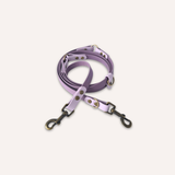 BioThane® original waterproof material, a lavender purple leather dog leash with antique bronze metal hardware, coiled on a light cream background.